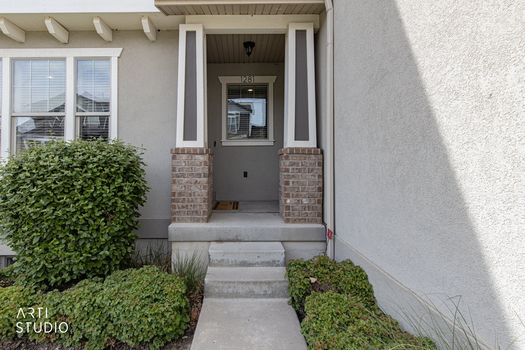 View of exterior entry featuring stucco siding and a porch