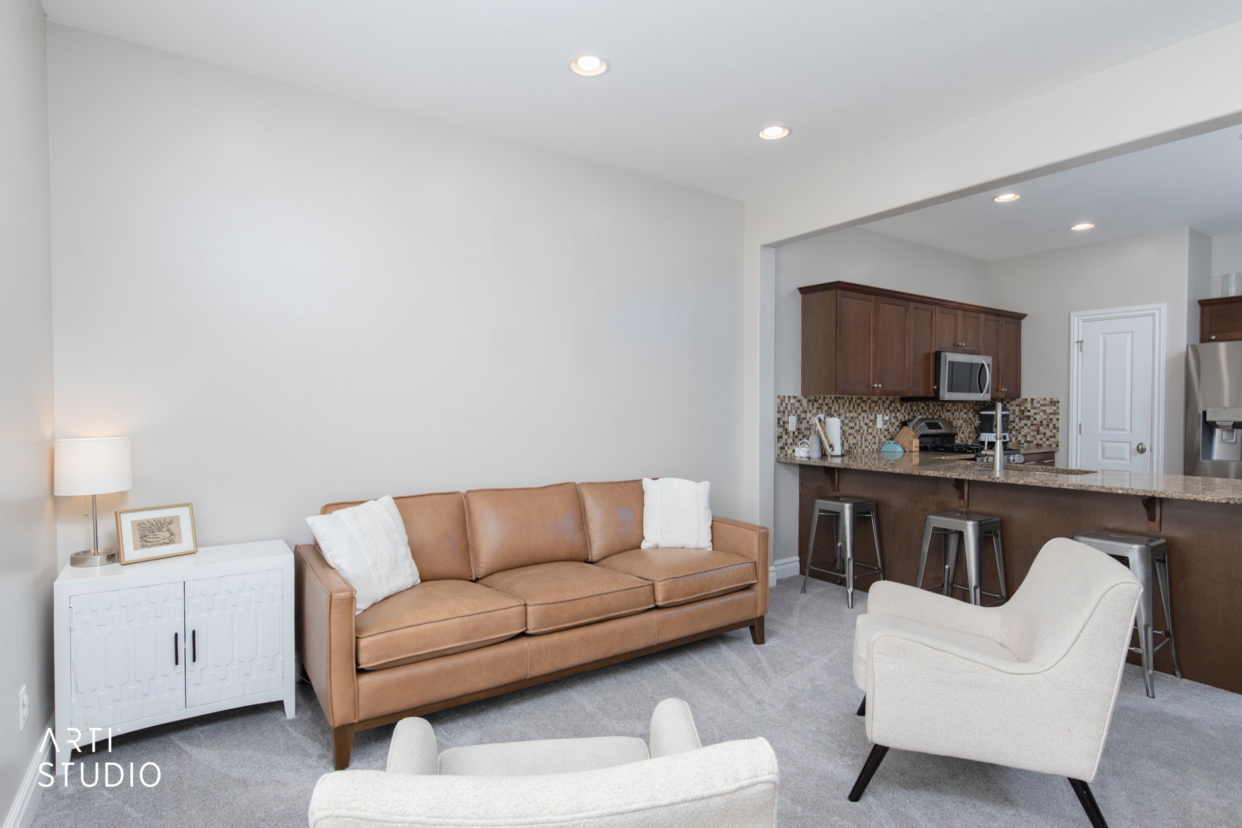 Living room with light colored carpet and recessed lighting
