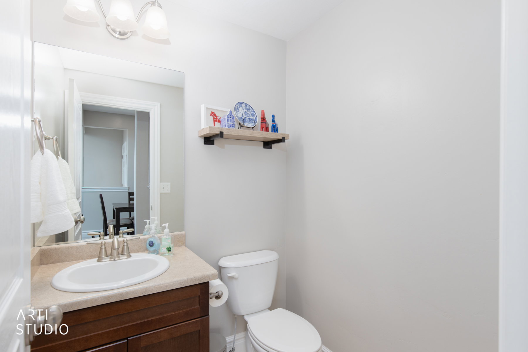 Main floor half bathroom featuring vanity and lighting.