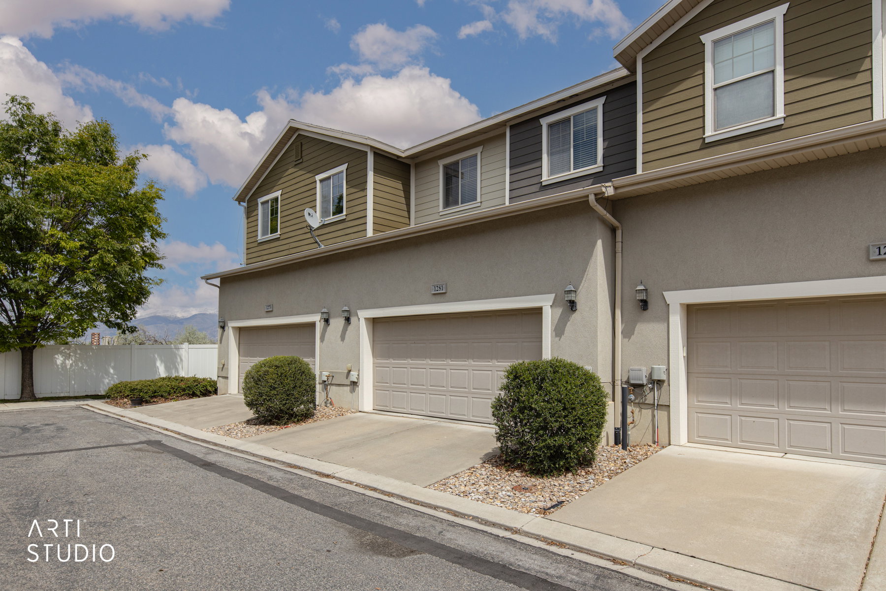 View of front of home with a garage, stucco siding, and driveway