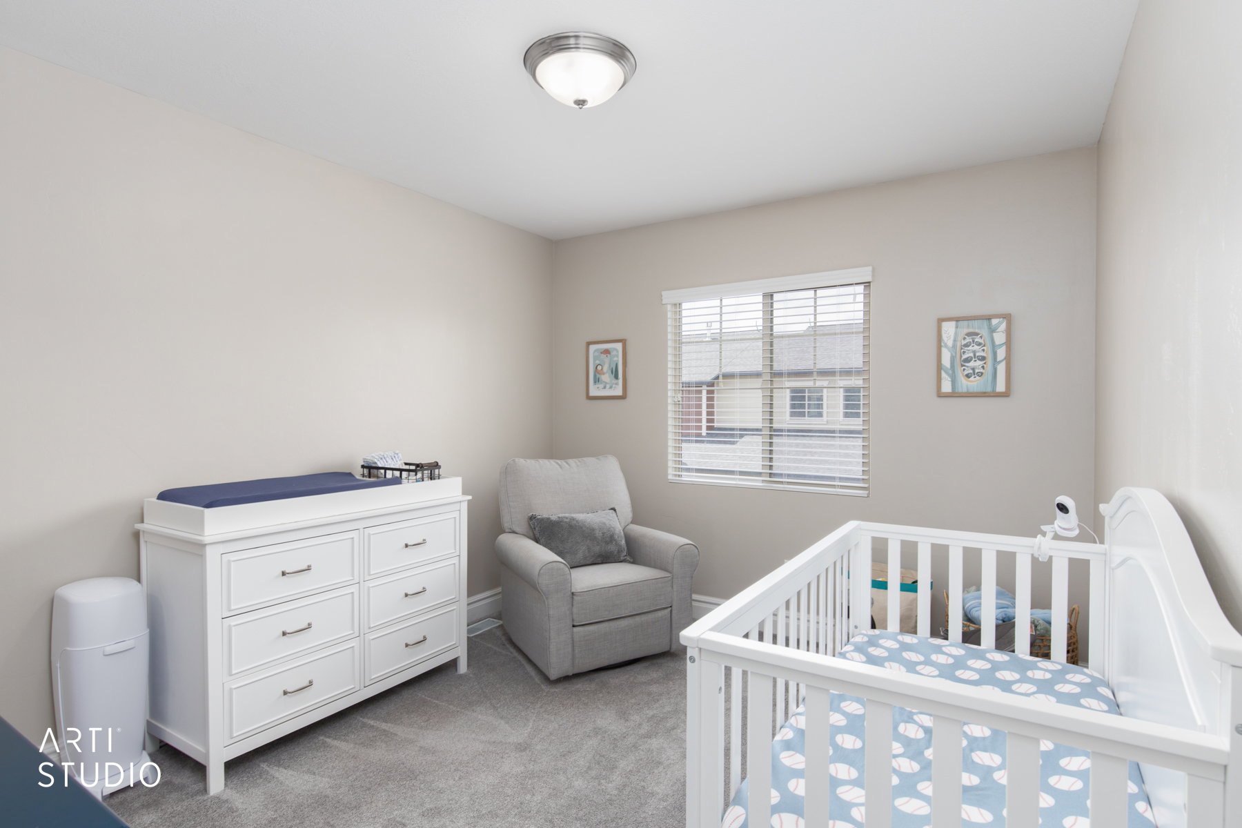 Bedroom featuring a nursery area and light colored carpet