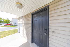 Entrance to property with a garage and covered porch