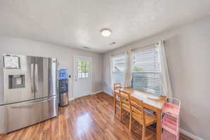 Dining area featuring light wood-style floors and a textured ceiling