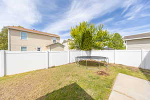 Fenced backyard with a trampoline