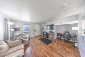 Living area featuring wood finished floors and a textured ceiling
