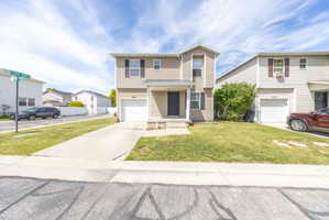 Traditional-style home with an attached garage, a front lawn, and driveway