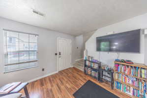 Foyer entrance with wood finished floors and a textured ceiling