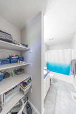 Full bathroom with vanity, shower / bath combo with shower curtain, and a textured ceiling