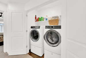 Laundry area featuring separate washer and dryer and wood finished floors