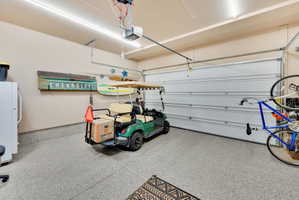 Garage featuring white fridge and a garage door opener
