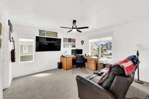 Office area with light carpet and a ceiling fan