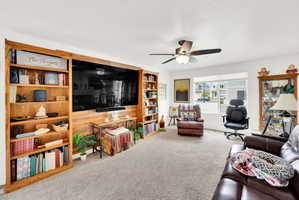 Living room featuring carpet floors and a ceiling fan