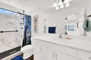 Full bathroom featuring connected bathroom, a marble finish shower, vanity, and recessed lighting