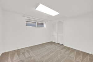 Finished basement featuring baseboards and light carpet