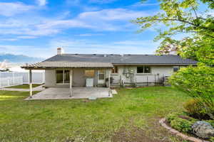 Rear view of property featuring a patio area, a fenced backyard, a chimney, and brick siding