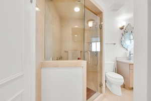Full bath featuring vanity, a stall shower, and light tile patterned flooring