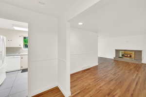 Unfurnished living room with a brick fireplace, light wood finished floors, and recessed lighting