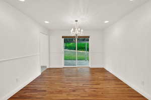Unfurnished dining area with suspended lighting and wood finished floors
