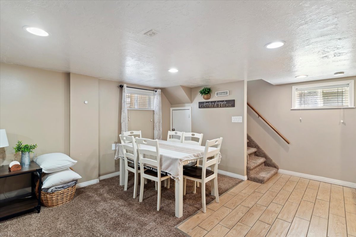 Dining room with tile floors, carpet, a textured ceiling, and recessed lighting