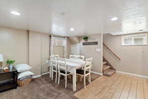 Dining room with tile floors, carpet, a textured ceiling, and recessed lighting