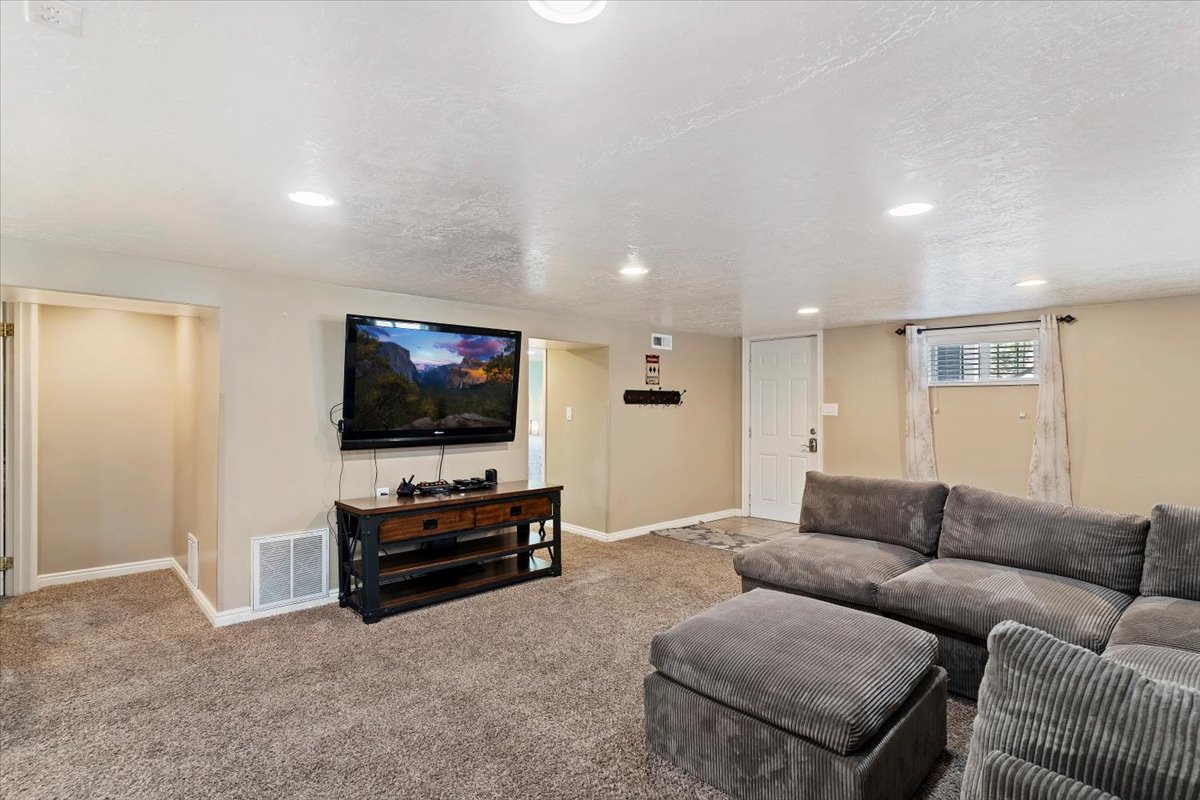 Carpeted great room featuring recessed lighting, and exterior door