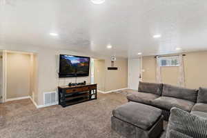 Carpeted great room featuring recessed lighting, and exterior door
