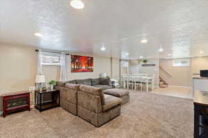 Living area featuring light carpet, a textured ceiling, and recessed lighting