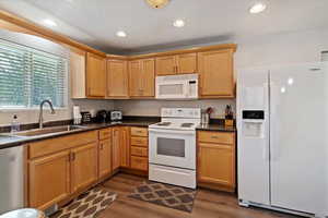 Kitchen featuring white & Stainless appliances, recessed lighting, LVP floors, and maple cabinetry
