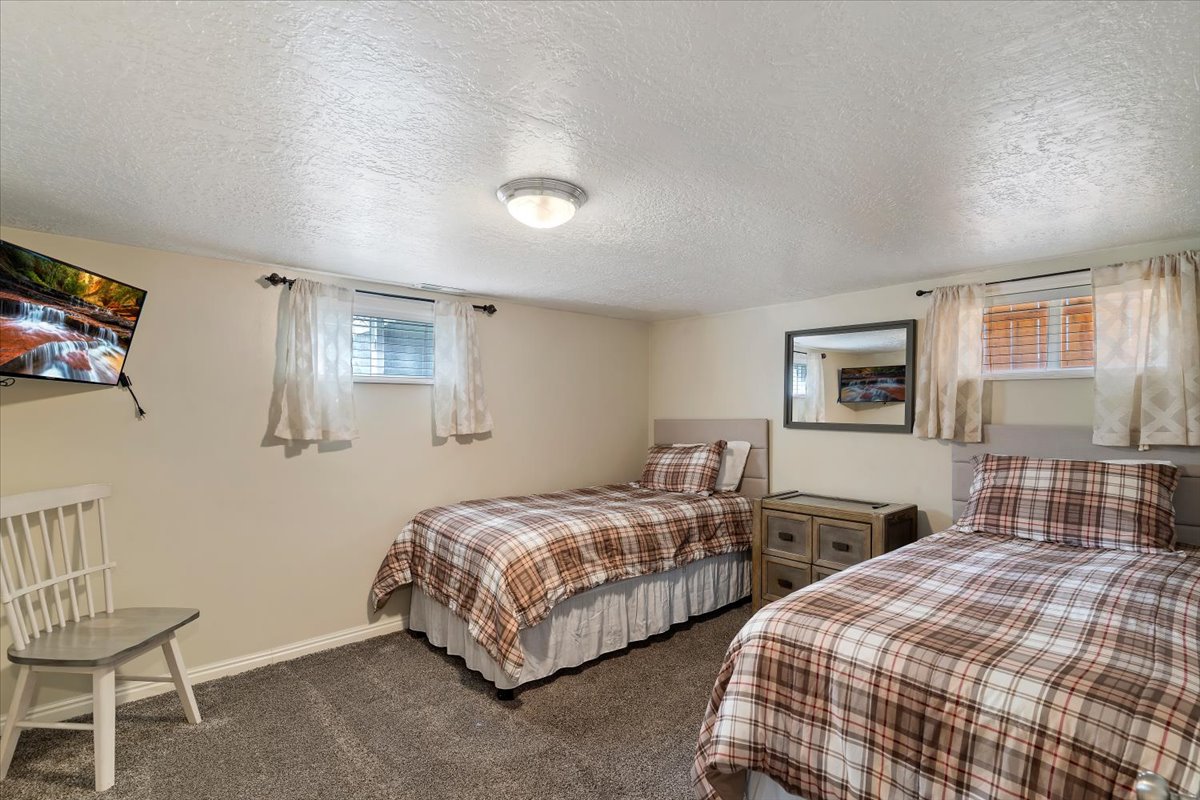 Bedroom featuring a textured ceiling and dark carpet