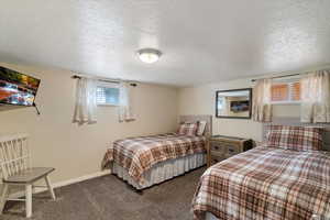 Bedroom featuring a textured ceiling and dark carpet