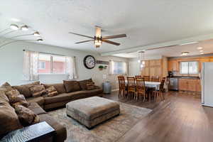 Living room with ceiling fan, LVP flooring, healthy amount of natural light, and a textured ceiling