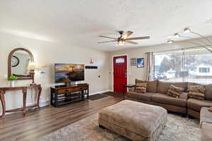 Living area with LVP floors, a ceiling fan, and large picture window
