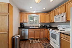 Kitchen with white & stainless appliances, LVP flooring, and recessed lighting