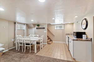 Dining room featuring a textured ceiling, recessed lighting, and tile & carpet floors