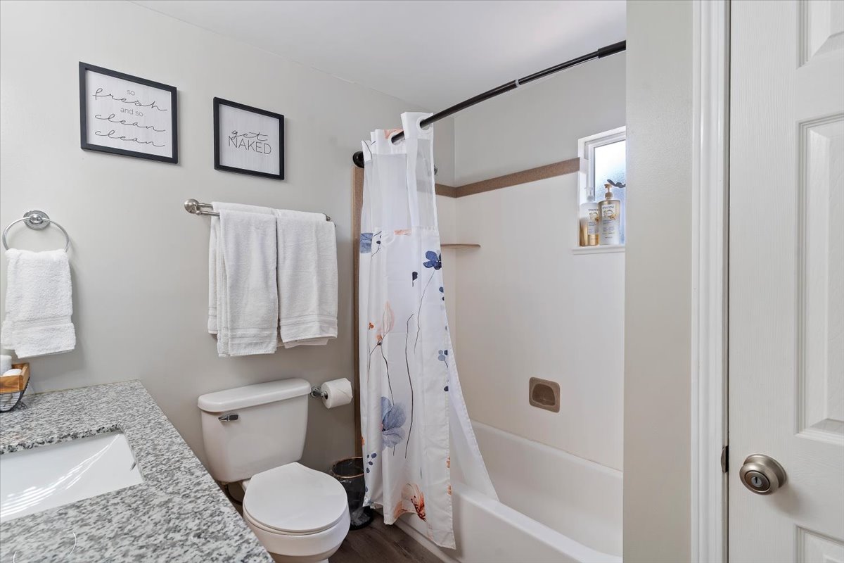 Bathroom featuring shower / bathtub combination with curtain and vanity