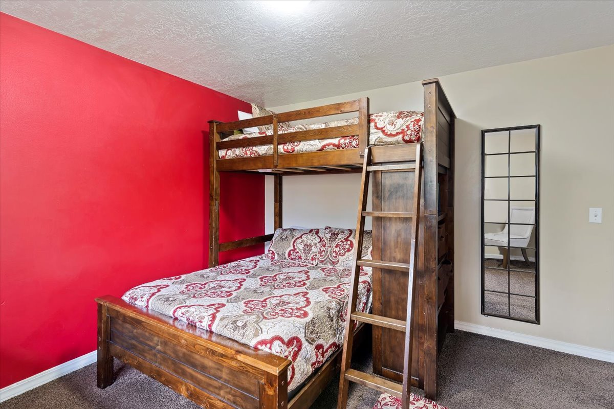 Bedroom featuring carpet and a textured ceiling