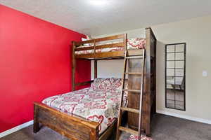 Bedroom featuring carpet and a textured ceiling