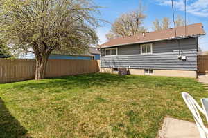 Rear view of property with a fenced backyard