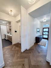 Front door and entry, beginning of wraparound hallway with access to garage and laundry room.
