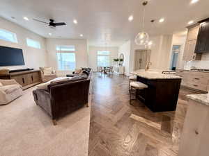 Living room with recessed lighting, ceiling fan, with carpet and hardwood herringbone floors