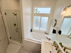 Master bathroom with a shower stall and a garden tub