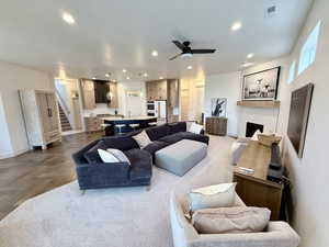 Living area featuring a fireplace, ceiling fan, parquet flooring, and recessed lighting