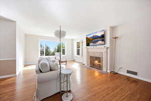 Living room featuring light wood-type flooring and a tile fireplace
