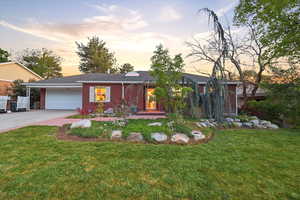 Ranch-style home featuring brick siding, a front yard, a garage, concrete driveway, and a shingled roof