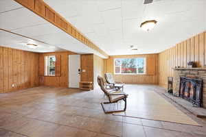Sitting room with a stone fireplace and wood walls