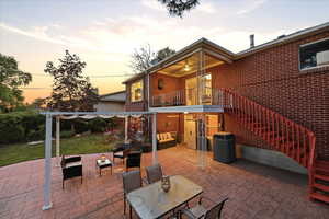 Patio terrace at dusk with a balcony, a patio area, a yard, and outdoor lounge area