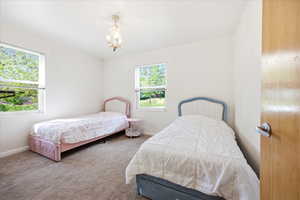 Bedroom featuring carpet and a chandelier