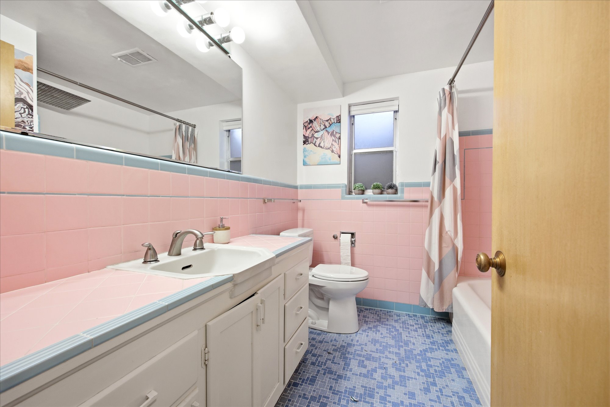 Full bathroom featuring vanity, wainscoting, tile walls, shower / bath combo, and dark tile patterned flooring