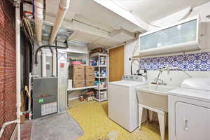 Laundry room featuring light flooring, independent washer and dryer, and heating unit