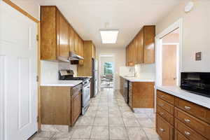 Kitchen featuring wood finish cabinetry, light countertops, and stainless steel appliances